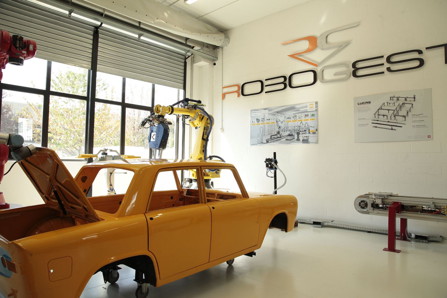 Robogest — showroom con robot industriali e scocca auto